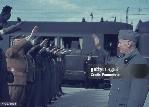 1st OCTOBER: Italian Prime Minister Benito Mussolini takes a salute from Axis officers at the railway station in Florence, Italy during a visit by...