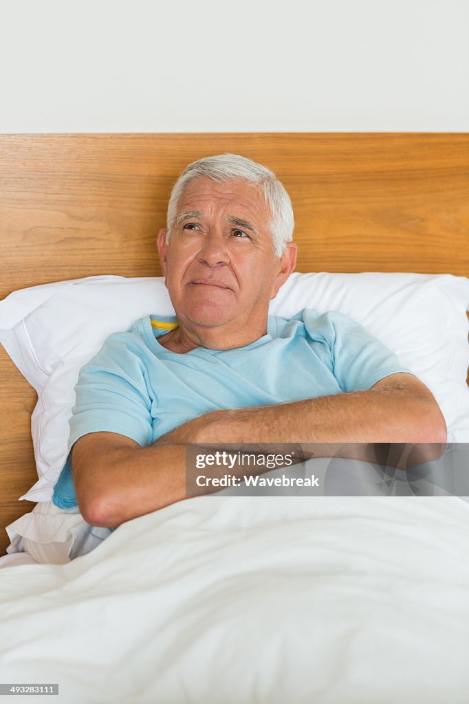 Senior man reclining on bed