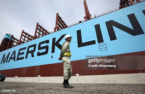 Worker walks past the Marstal Maersk Triple-E Class container ship, operated by A.P. Moeller-Maersk A/S, berthed at the company's container yard in...