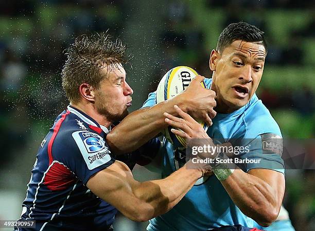 Israel Folau of the Waratahs is tackled by Jason Woodward of the Rebels during the round 15 Super Rugby match between the Rebels and the Waratahs at...