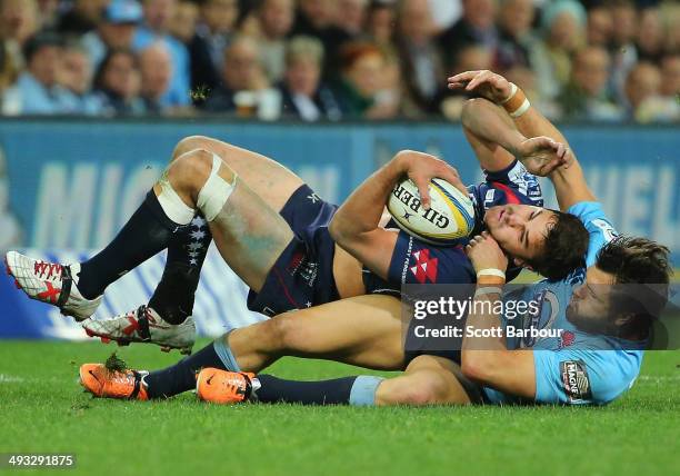 Tom English of the Rebels is tackled by Adam Ashley-Cooper of the Waratahs during the round 15 Super Rugby match between the Rebels and the Waratahs...