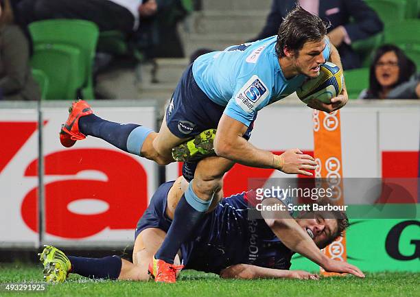 Rob Horne of the Waratahs scores a try in the corner despite the tackle of Jason Woodward of the Rebels during the round 15 Super Rugby match between...