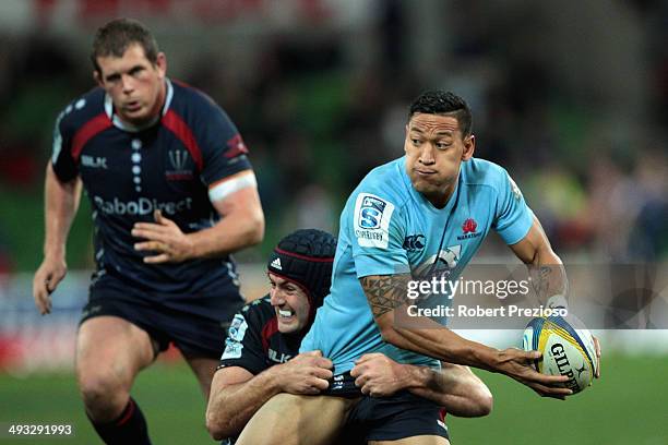 Israel Folau of the Waratahs is tackled by Cadeyrn Neville of the Rebels during the round 15 Super Rugby match between the Rebels and the Waratahs at...