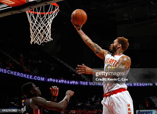 Mike Scott of the Atlanta Hawks lays in a basket against James Ennis of the Miami Heat at Philips Arena on October 18, 2015 in Atlanta, Georgia. NOTE...