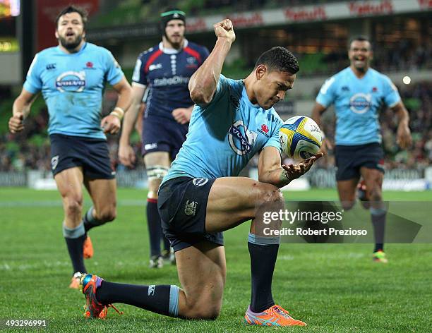 Israel Folau of the Waratahs celebrates after crossing the line to score a try during the round 15 Super Rugby match between the Rebels and the...