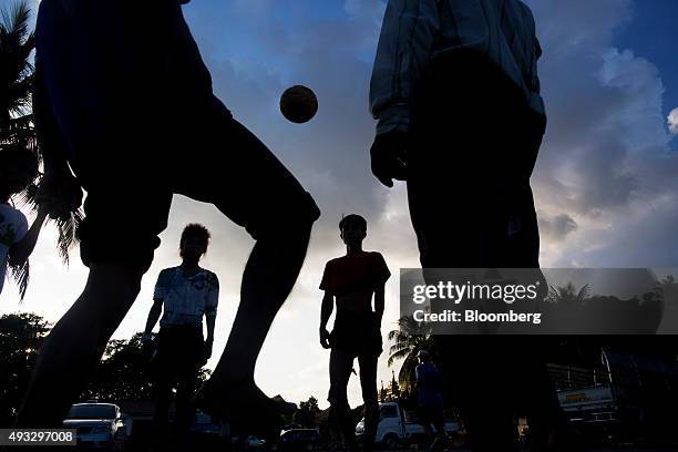 Men are silhouetted as they play caneball, a traditional sport known in Myanmar as chinlone, in Yangon, Myanmar, on Thursday, Oct. 15, 2015....