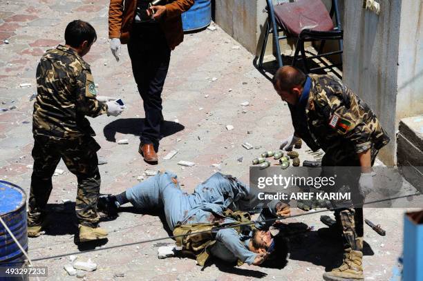 Afghan security personnel check the body of insurgent following an attack by insurgents on the Indian consulate in Herat on May 23 ,2014. Four...