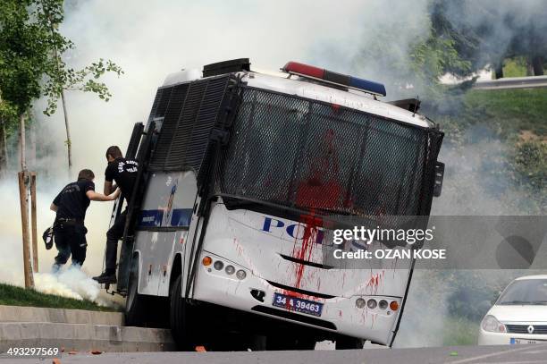 Riot police officers run away from their bus while protesters attack them during a demonstration against the recent mine accident in Soma, on May 23...