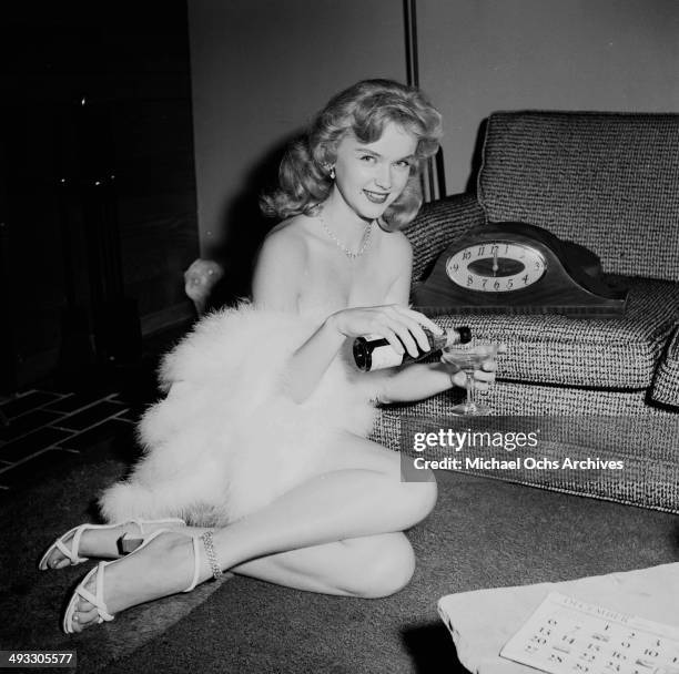 Circa 1953: Actress Anne Francis poses with champagne in Los Angeles, California.