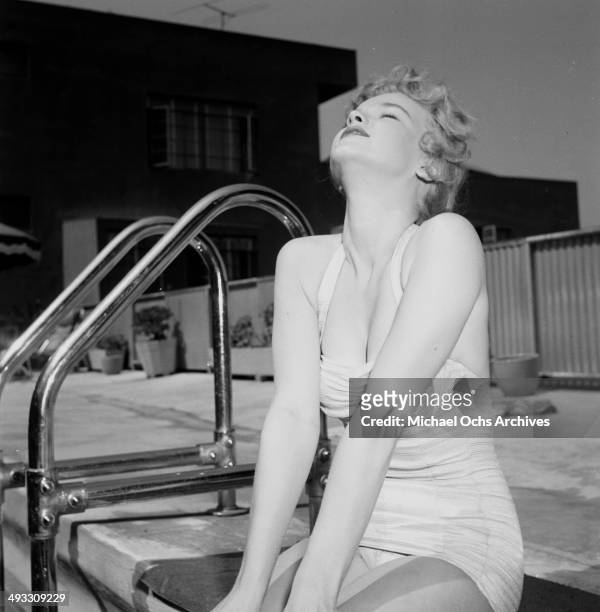 Circa 1953: Actress Anne Francis poses by the swimming pool in Los Angeles, California.