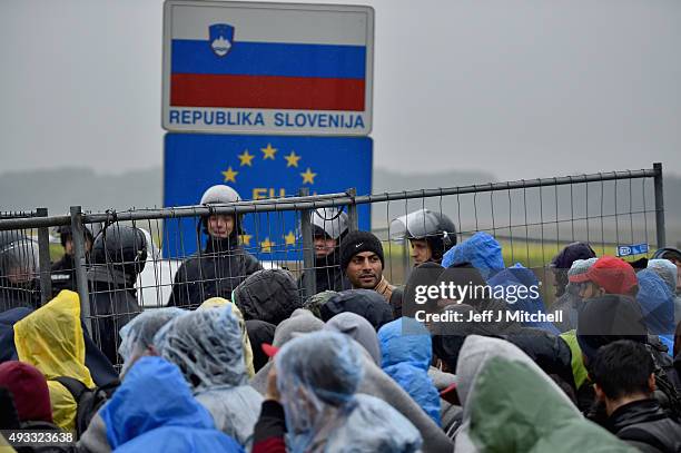 Migrants wait in the rain at the Trnovec border crossing with Slovenia as restrictions on movements have produced bottlenecks on Croatia's borders,...