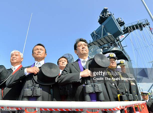 Japanese Prime Minister Shinzo Abe , Deputy Prime Minister Taro Aso and Defense Minister Gen Nakatani inspect the Japan Maritime Self-Defense Force...