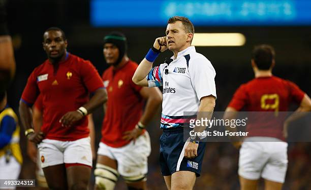 Referee Nigel Owens listens to the TMO during the 2015 Rugby World Cup Quarter Final match between New Zealand and France at Millennium Stadium on...