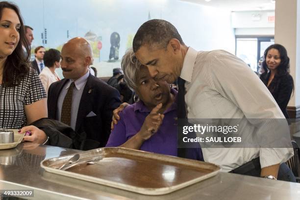 President Barack Obama greets a restaurant patron after ordering breakfast during a surprise visit to Valois Cafeteria in Chicago, Illinois on May...
