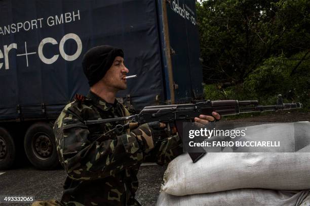 Gunman from the Vostok Battalion, a pro-Russia militia, points his gun as he stands guard at a checkpoint in Pisky, some 15 km from Donetsk, eastern...