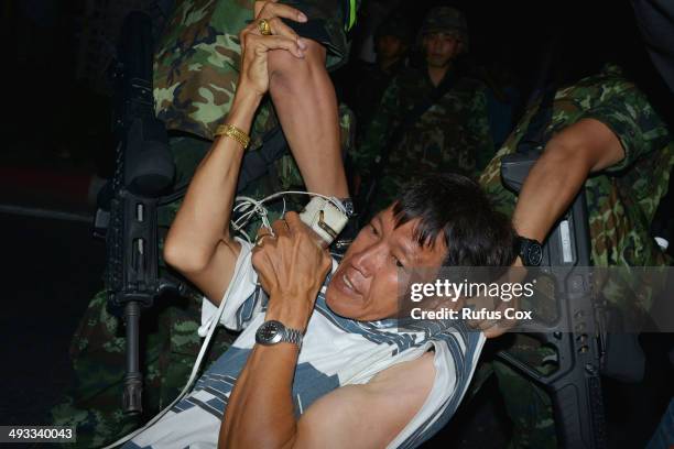 Protester is dragged away by Thai army soldiers while taking part in anti-coup rally on May 23, 2014 in Bangkok, Thailand. Anti-coup protesters...