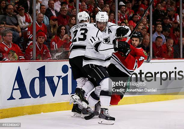 Anze Kopitar and Dustin Brown of the Los Angeles Kings vie for position with Niklas Hjalmarsson of the Chicago Blackhawks in Game Two of the Western...