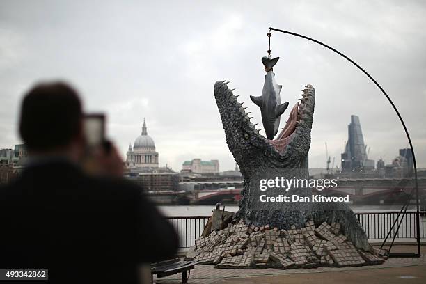 People take photographs of a model of a Mosasaurus on the South Bank on October 19, 2015 in London, England. The model dinosaur formed part of the...