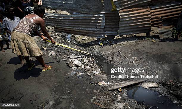 Beira, Mozambique A woman cleans a moat in a slum in the city area of Beira on September 28, 2015 in Beira, Mozambique.