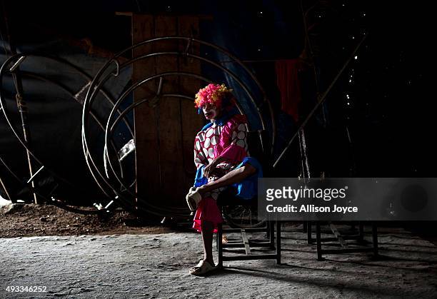 Clown in costume waits quietly backstage before a show on October 17, 2015 at the Rambo Circus in Pimpri, India. The Rambo Circus travels throughout...