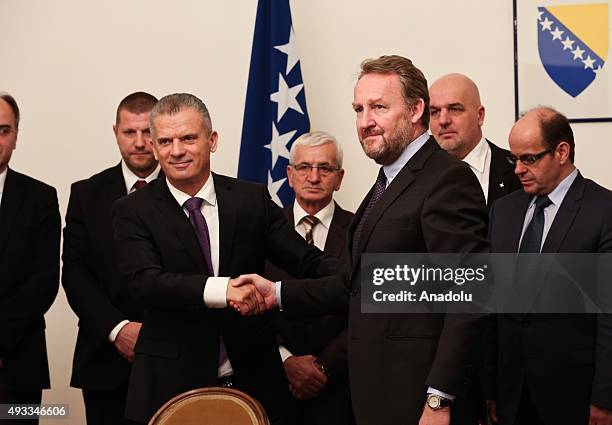 Leader of Party of Democratic Action Bakir Izetbegovic shakes hands with Leader of Union for a Better Future Fahrudin Radoncic after they signed a...