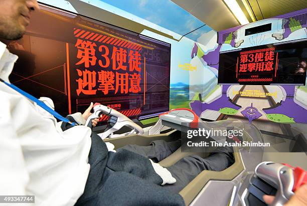 Staff demonstrates the video game passengers can play in the head coach of the popular animation series 'Neon Genesis Evangelion' themed Shinkansen...