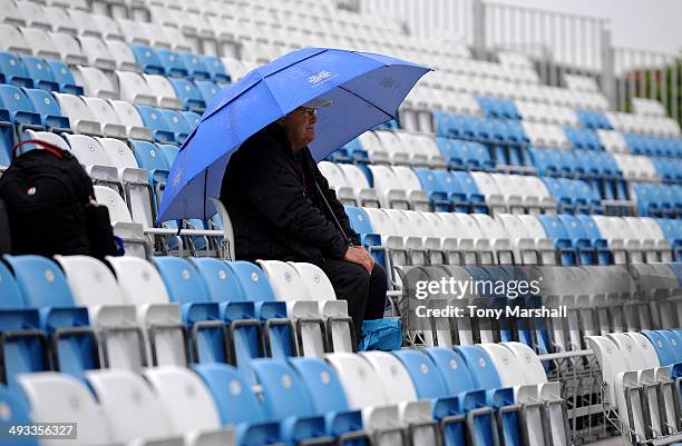 Lone cricket fan sits under an umbrella as the rain comes down at The County Ground during the NatWest T20 Blast match between Derbyshire Falcons and...