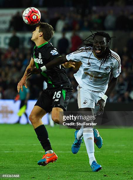 Bafetimbi Gomis of Swansea City is beaten to the ball by Philipp Wollscheid of Stoke City during the Barclays Premier League match between Swansea...