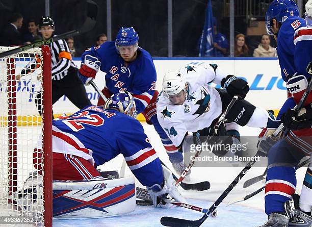 Antti Raanta and Oscar Lindberg of the New York Rangers defend against Dylan DeMelo of the San Jose Sharks during the first period at Madison Square...