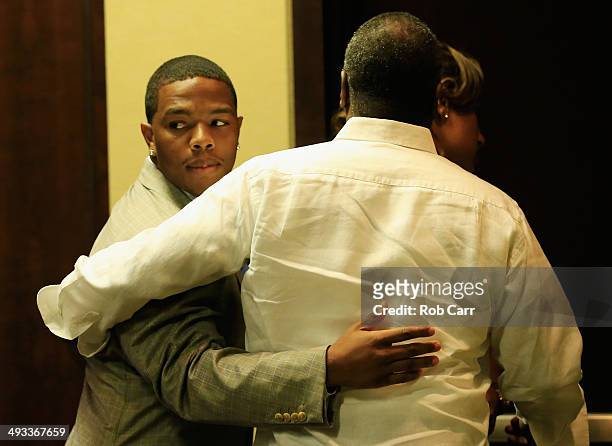 Running back Ray Rice of the Baltimore Ravens gets a hug from his wife Janay and father in law Joe Palmer following a news conference at the Ravens...