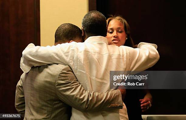 Running back Ray Rice of the Baltimore Ravens gets a hug from his wife Janay and father in law Joe Palmer following a news conference at the Ravens...