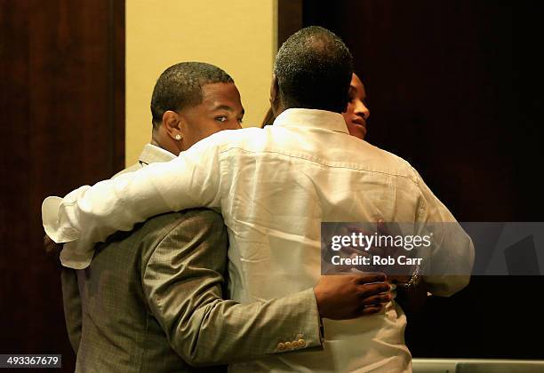 Running back Ray Rice of the Baltimore Ravens gets a hug from his wife Janay and father in law Joe Palmer following a news conference at the Ravens...