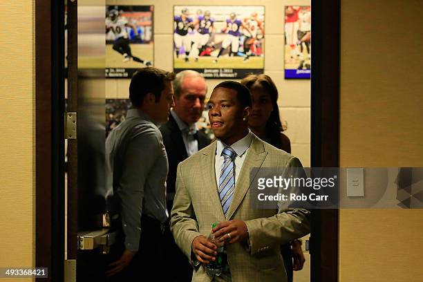 Baltimore Ravens assistant director of public relations Patrick M. Gleason holds the door as running back Ray Rice enter a news conference followed...