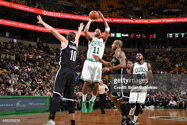 Evan Turner of the Boston Celtics shoots against Sergey Karasev of the Brooklyn Nets during the preseason game on October 19, 2015 at TD Garden in...