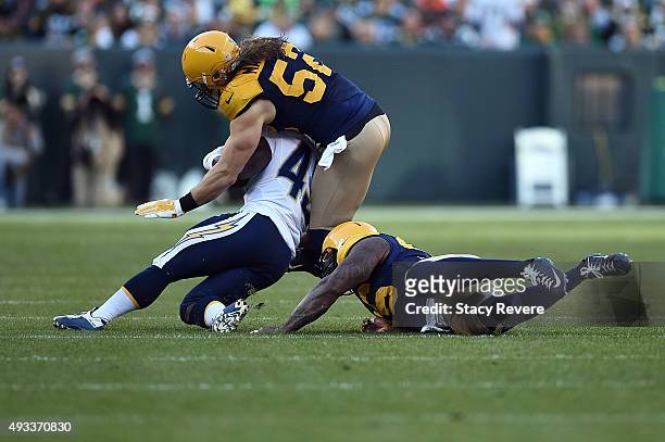 Branden Oliver of the San Diego Chargers is brought down by Mike Neal and Clay Matthews of the Green Bay Packers during a game at Lambeau Field on...