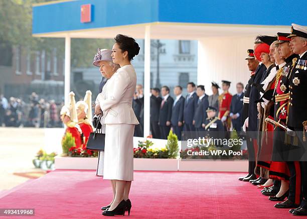 Queen Elizabeth II and the Chinese First Lady Peng Liyuan watch as Chinese President Xi Jinping inspects a guard of honour during the official...