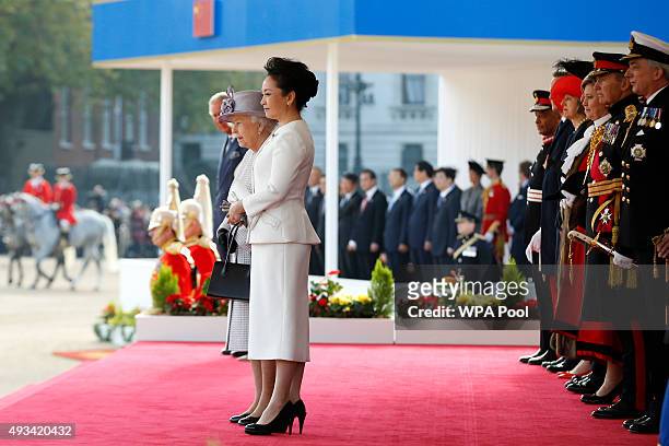 Queen Elizabeth II and the Chinese First Lady Peng Liyuan watch as Chinese President Xi Jinping inspects a guard of honour during the official...