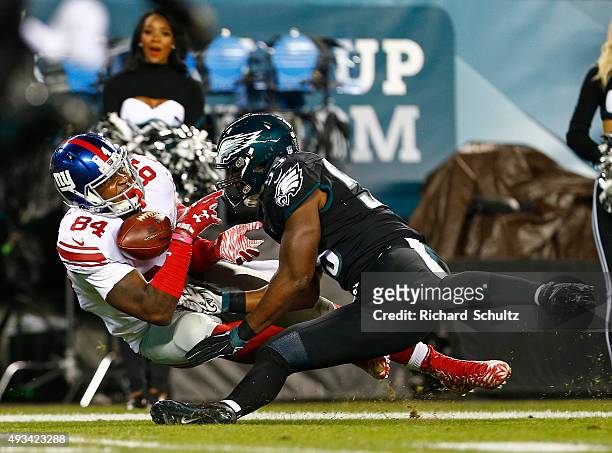 Larry Donnell of the New York Giants can't control the ball as he is hit by DeMeco Ryans of the Philadelphia Eagles during the first quarter of a...