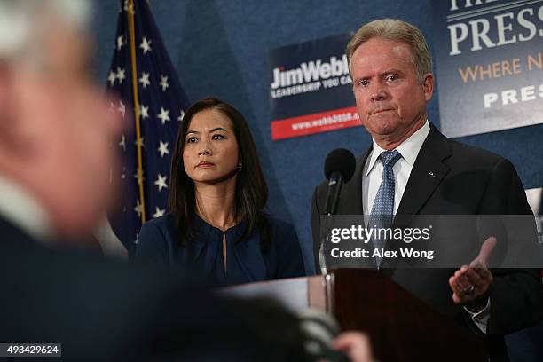Former U.S. Sen. Jim Webb speaks as his wife Hong Le Webb listens during a news conference at the National Press Club October 20, 2015 in Washington,...
