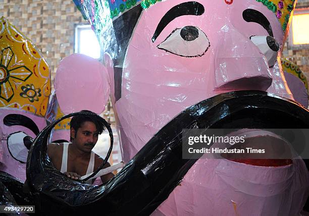 Final touches are being given by artists to the effigies of the mythical demon King Ravana for the upcoming Dussehra festival on October 20, 2015 in...
