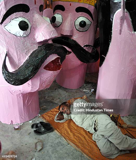 Artist taking rest after giving final touches to the effigies of the mythical demon King Ravana for the upcoming Dussehra festival on October 20,...
