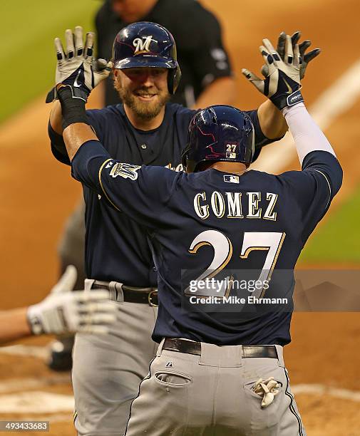 Mark Reynolds of the Milwaukee Brewers is congratulated by Carlos Gomez after hitting a two run home run during a game against the Miami Marlins at...