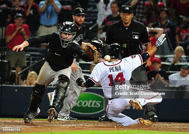 Ramiro Pena of the Atlanta Braves scores the go-ahead run in the 8th inning against Jordan Pacheco of the Colorado Rockies at Turner Field on May 23,...