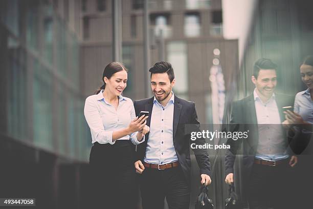 young business woman with  colleague walking  in the business district - two international finance center stock pictures, royalty-free photos & images