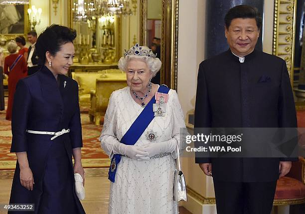 President of China Xi Jinping and his wife Peng Liyuan accompany Britain's Queen Elizabeth II as they arrive for a state banquet at Buckingham Palace...