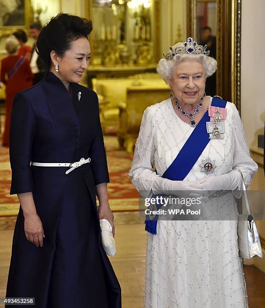 Peng Liyuan , the wife of President of China Xi Jinping, accompanies Britain's Queen Elizabeth II as they arrive for a state banquet at Buckingham...