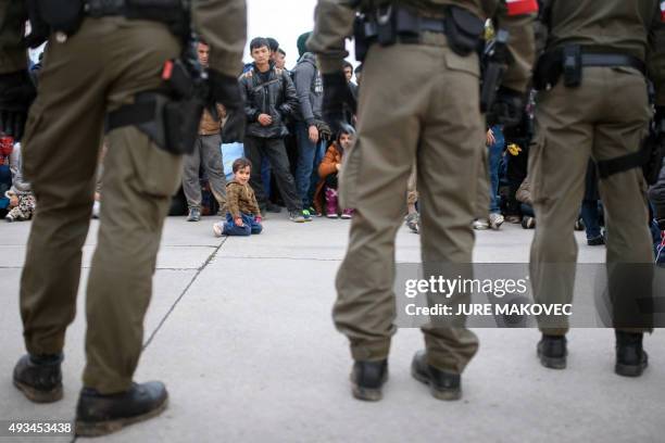 Migrants and refugees wait to be transfered to an Austrian refugee center at the Slovenian-Austrian border in Sentilj on October 20, 2015. Slovenia...