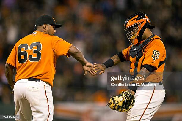 Jean Machi of the San Francisco Giants celebrates with Hector Sanchez after the game against the Minnesota Twins at AT&T Park on May 23, 2014 in San...