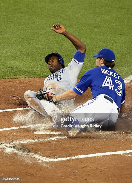 Lorenzo Cain of the Kansas City Royals scores a run in the first inning as R.A. Dickey of the Toronto Blue Jays attempts to make the tag during game...