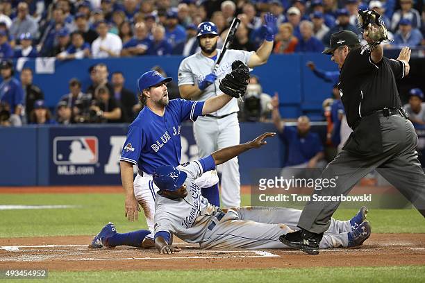 Lorenzo Cain of the Kansas City Royals scores a run in the first inning after R.A. Dickey of the Toronto Blue Jays attempts to make the tag during...